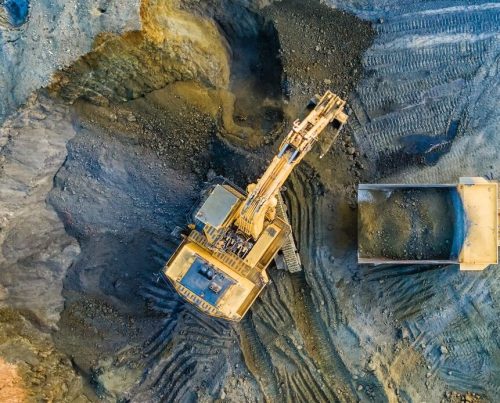 Quarry mining, work of the excavator and dump trucks, photo from the air